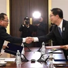 Trưởng đoàn đàm phán Hàn Quốc Chun Hae-sung (phải) và người đồng cấp Triều Tiên Jon Jong-su trao đổi văn kiện chung tại cuộc đàm phán cấp chuyên viên ở làng đình chiến Panmunjom ngày 17/1/2018. (Ảnh: AFP/TTXVN)