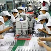 Công nhân làm việc trên dây chuyền sản xuất động cơ siêu nhỏ tại nhà máy ở Hoài Bắc, An Huy, Trung Quốc. (Ảnh: AFP/TTXVN)