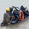 Người dân Phú Yên phải di chuyển bằng thuyền qua vùng ngập nước. (Ảnh: Thế Lập/TTXVN)