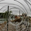 Binh sỹ Mỹ dựng hàng rào an ninh tại khu vực biên giới với Mexico ở Laredo, bang Texas (Mỹ). (Ảnh: AFP/TTXVN)