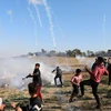 Binh sỹ Israel bắn đạn hơi cay về phía người biểu tình Palestine trong cuộc đụng độ tại khu vực biên giới Israel và Dải Gaza ngày 19/4. (Ảnh: THX/TTXVN)