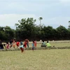 Không có sân chơi, trẻ em ở xã Phước Nam (huyện Thuận Nam, Ninh Thuận) phải đá bóng trên mặt ruộng. (Ảnh: Công Thử/TTXVN)