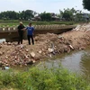 Người dân đổ đất lấp ngang đoạn kênh qua địa bàn thôn Điền Chánh Trung. (Ảnh: Phước Ngọc/TTXVN)