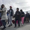 Người di cư Trung Mỹ vượt qua hàng rào biên giới khi di chuyển từ Tijuana, bang Baja California (Mexico) tới San Diego, Mỹ, ngày 21/3/2019. (Ảnh: AFP/TTXVN)