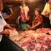 Lực lượng chức năng kiểm tra buôn bán thịt lợn tại các chợ xã. (Ảnh: Huỳnh Phúc Hậu/TTXVN)