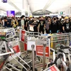 Người biểu tình phong tỏa lối vào sân bay quốc tế Hong Kong tối 13/8. (Ảnh: AFP/TTXVN)