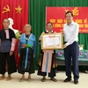 Bộ trưởng Bộ Lao động-Thương binh và Xã hội Đào Ngọc Dung trao Bằng Tổ quốc ghi công cho thân nhân Liệt sỹ Thao Văn Súa. (Nguồn: TTXVN)