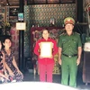 Đại diện Công an tỉnh Tây Ninh trao quyết định truy thăng cấp hàm từ hạ sỹ lên trung sỹ cho gia đình chiến sỹ Trần Văn Lành. (Ảnh: Lê Đức Hoảnh/TTXVN)