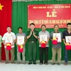 Lãnh đạo bộ đội biên phòng Sóc Trăng trao tặng cờ và ảnh bác Hồ cho ngư dân vùng ven biển Sóc Trăng. (Ảnh: Trung Hiếu-TTXVN)
