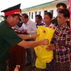 Lãnh đạo Bộ Chỉ huy Quân sự tỉnh Đắk Nông tặng quà cho người nghèo xã Senmonorum. (Ảnh: TTXVN phát)