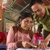 Người dân được chỉ bảo tận tình từng nét chữ trong lớp dạy chữ cho những người Việt kiều Campuchia lớn tuổi trên lòng hồ Trị An. (Ảnh: Lê Xuân/TTXVN)