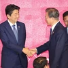 Tổng thống Moon Jae-in (phải) bắt tay Thủ tướng Nhật Bản Abe Shinzo. (Nguồn: Yonhap)
