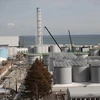 Lò phản ứng số 4 (trái) và các bể chứa nước nhiễm xạ tại nhà máy điện hạt nhân Fukushima Daiichi ở tỉnh Fukushima, Nhật Bản. (Ảnh: AFP/TTXVN)