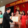Bộ trưởng Phùng Xuân Nhạ trao bằng khen cho các giáo viên có thành tích xuất sắc trong công tác giáo dục mầm non. (Ảnh: Thanh Tùng/TTXVN)
