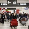 Hành khách đeo khẩu trang đề phòng lây nhiễm virus corona tại sân bay quốc tế Toronto Pearson, Canada. (Ảnh: AFP/TTXVN)