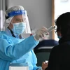 Nhân viên y tế kiểm tra thân nhiệt cho một bệnh nhân tại bệnh viện Princess Margaret ở Hong Kong ngày 4/2/2020. (Ảnh: AFP/TTXVN)