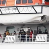 Các hành khách trên tàu du lịch Diamond Princess tại khu vực cách ly cảng Yokohama, Nhật Bản, ngày 14/2. (Ảnh: AFP/TTXVN)