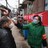 Kiểm tra thân nhiệt của người dân nhằm ngăn chặn sự lây lan của COVID-19 tại Vũ Hán, tỉnh Hồ Bắc, Trung Quốc. (Ảnh: THX/TTXVN)