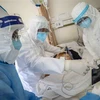 Nhân viên y tế điều trị cho bệnh nhân nhiễm COVID-19 tại bệnh viện ở Vũ Hán, Trung Quốc. (Ảnh: AFP/TTXVN)