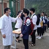 Trường THPT số 1 huyện Bát Xát, tỉnh Lào Cai phối hợp với trung tâm y tế địa phương đo thân nhiệt cho các học sinh và hướng dẫn thực hiện các bước phòng chống dịch trước khi vào lớp học. (Ảnh: Hương Thu/TTXVN)