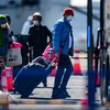Hành khách lên xe buýt sau khi kết thúc thời gian cách ly và rời khỏi du thuyền Diamond Princess tại cảng Daikoku, Yohohama, Nhật Bản, ngày 21/2/2020. (Ảnh: AFP/TTXVN)