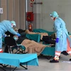 Nhân viên y tế điều trị cho bệnh nhân mắc COVID-19 tại một bệnh viện dã chiến ở vùng Lombardy, Italy. (Ảnh: AFP/TTXVN)