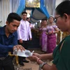 Người dân rửa tay phòng lây nhiễm COVID-19 trước khi dự một lễ cưới ở Phnom Penh, Campuchia. (Ảnh: AFP/TTXVN)