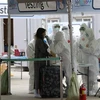 Nhân viên y tế lấy mẫu bệnh phẩm xét nghiệm COVID-19 đối với hành khách đến từ châu Âu tại sân bay quốc tế Incheon, phía tây thủ đô Seoul, Hàn Quốc. (Ảnh: Yonhap/TTXVN)