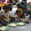 Người vô gia cư nhận thức ăn từ một chương trình cứu trợ dành cho người nghèo ở Hyderabad, Ấn Độ nắm 2019. (Ảnh: AFP/TTXVN)
