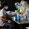 Nhân viên y tế lấy mẫu xét nghiệm COVID-19 tại chợ ở Banten, Indonesia. (Ảnh: THX/TTXVN)