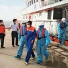 Hai thuyền viên Indonesia được đưa vào bờ an toàn. (Ảnh: TTXVN phát)