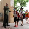 Học sinh Trường Tiểu học Nghĩa Tân, quận Cầu Giấy được kiểm tra thân nhiệt khi tới trường. (Ảnh: Thanh Tùng/TTXVN)