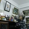 Bà Nguyễn Thị Nương đang thắp hương trên bàn thờ Bác Hồ tại nhà riêng, đây là bàn thờ mà bà đã lập từ năm 1976 khi từ Pháp trở về Lào. (Ảnh: Phạm Kiên/Vietnam+)