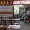 Một cửa hàng chỉ bán đồ ăn mang về nhằm tránh tụ tập đông người tại Singapore trong bối cảnh dịch COVID-19 bùng phát. (Ảnh: AFP/TTXVN)