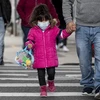 Một em nhỏ đeo khẩu trang phòng dịch COVID-19. (Ảnh: AFP/TTXVN)