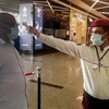 Kiểm tra thân nhiệt cho người dân tại một trung tâm mua sắm ở Riyadh, Saudi Arabia nhằm ngăn chặn sự lây lan của dịch COVID-19. (Ảnh: AFP/TTXVN)