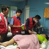 Phó Chủ tịch, Tổng Thư ký Trung ương Hội Chữ thập Đỏ Việt Nam Nguyễn Hải Anh (người đeo khẩu trang trắng) thăm hỏi và động viên các nạn nhân. (Ảnh: Minh Huệ/TTXVN)