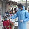 Nhân viên y tế lấy mẫu dịch xét nghiệm COVID-19 cho người dân tại một khu chợ ở Bangalore, Ấn Độ. (Ảnh: THX/TTXVN)