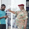 Binh lính Nam Phi tiến hành đo kiểm tra thân nhiệt cho người dân. (Ảnh: TTXVN)