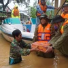 Lực lượng công an tỉnh Thừa Thiên-Huế trao tặng mì tôm cho các gia đình vùng trũng. (Ảnh: TTXVN phát)