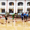 Các đội hình xung kích, tình nguyện của Tuổi trẻ Quảng Bình hăng hái giúp các trường học dọn vệ sinh, khắc phục hậu quả mưa lũ. (Ảnh: Võ Dung/TTXVN)