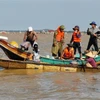 Người dân Lệ Thủy, Quảng Bình chèo thuyền đi lấy hàng cứu trợ do địa hình phức tạp khiến lực lượng chức năng không thể tiếp cận. (Ảnh: Thành Đạt/TTXVN)