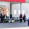 Người dân xếp hàng bên ngoài siêu thị ở Berlin, Đức. (Ảnh: THX/TTXVN)