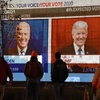Người dân theo dõi kết quả trực tiếp cuộc bầu cử Tổng thống Mỹ giữa Tổng thống đương nhiệm Donald Trump (phải) và ứng viên Tổng thống đảng Dân chủ Joe Biden tại Washington DC., ngày 3/11/2020. (Ảnh: AFP/TTXVN)