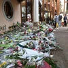 Người dân đặt hoa tưởng niệm thầy giáo Samuel Paty bị đối tượng Hồi giáo cực đoan sát hại, tại trường trung học Conflans-Sainte-Honorine, cách thủ đô Paris của Pháp 30km về phía tây bắc, ngày 17/10/2020. (Ảnh: AFP/TTXVN)