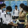 Các học sinh tiến hành sát khuẩn tay nhằm ngăn dịch COVID-19 lây lan, trước khi vào lớp ở Phnom Penh, Campuchia. (Ảnh: AFP/TTXVN)