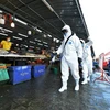 Nhân viên khử khuẩn nhằm ngăn dịch COVID-19 lây lan tại một khu chợ ở tỉnh Samut Sakhon, Thái Lan. (Ảnh: THX/TTXVN)