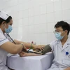 Nhân viên y tế Bệnh viện Bệnh Nhiệt đới Thành phố Hồ Chí Minh được khám sàng lọc trước khi tiêm vaccine phòng COVID-19. (Ảnh: Đinh Hằng/TTXVN)