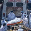 Nhân viên y tế chuyển thi thể bệnh nhân COVID-19 tới khu hỏa táng ở New Delhi, Ấn Độ. (Ảnh: AFP/TTXVN)