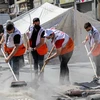 Các tình nguyện viên dọn dẹp đống đổ nát của các tòa nhà bị sập sau loạt không kích của Israel xuống Dải Gaza. (Ảnh: THX/TTXVN)